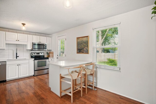 651 Dovalon Pl, Galloway, OH 43119 - kitchen featuring appliances with stainless steel finishes, a sink, white cabinetry, light countertops, and a textured ceiling