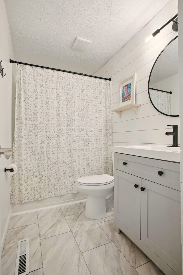 651 Dovalon Pl, Galloway, OH 43119 - bathroom with vanity, marble finish flooring, toilet, a textured ceiling, and shower / tub combo