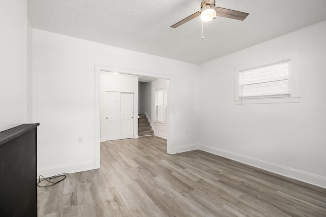 848-850 Carpenter St, Columbus, OH 43206 - unfurnished room with light wood-type flooring, a ceiling fan, baseboards, stairs, and a textured ceiling