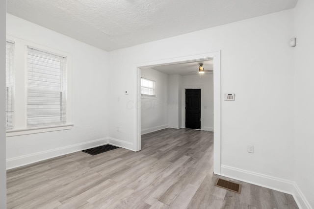 848-850 Carpenter St, Columbus, OH 43206 - empty room with light wood-style flooring, baseboards, a ceiling fan, and a textured ceiling