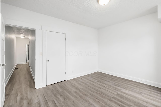 848-850 Carpenter St, Columbus, OH 43206 - unfurnished bedroom with wood finished floors, a textured ceiling, baseboards, and a closet