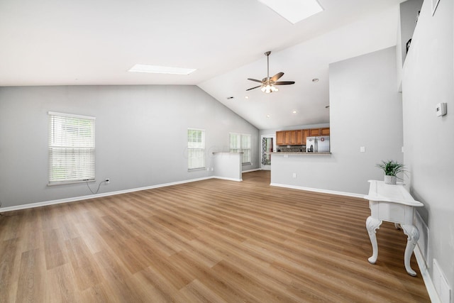 1472 Tall Meadows Dr, Columbus, OH 43223 - unfurnished living room with vaulted ceiling, healthy amount of natural light, a skylight, a ceiling fan, and light wood-type flooring