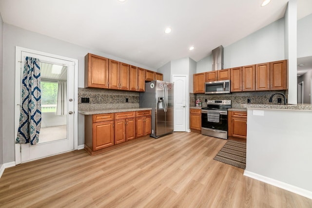 1472 Tall Meadows Dr, Columbus, OH 43223 - kitchen with appliances with stainless steel finishes, brown cabinets, vaulted ceiling, tasteful backsplash, and light wood finished floors
