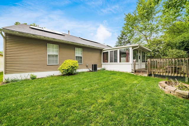 1472 Tall Meadows Dr, Columbus, OH 43223 - rear view of house featuring a sunroom, roof mounted solar panels, a lawn, and a wooden deck