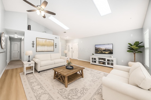 1472 Tall Meadows Dr, Columbus, OH 43223 - living area featuring a skylight, light wood-style flooring, ceiling fan, high vaulted ceiling, and baseboards