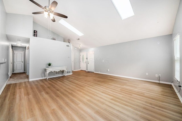 1472 Tall Meadows Dr, Columbus, OH 43223 - unfurnished living room featuring a skylight, ceiling fan, high vaulted ceiling, baseboards, and light wood-style flooring