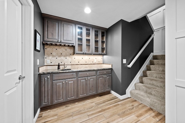 5568 Lexington Dr, Hilliard, OH 43026 - indoor wet bar with light wood-style floors, decorative backsplash, baseboards, and stairway