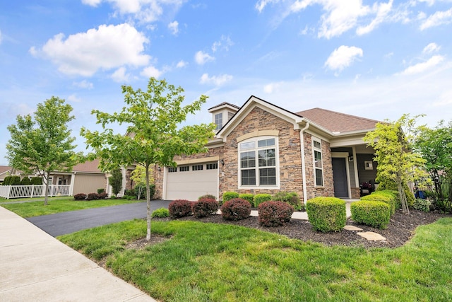5568 Lexington Dr, Hilliard, OH 43026 - view of front of house featuring stone siding, an attached garage, and asphalt driveway