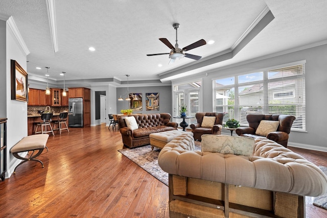 5568 Lexington Dr, Hilliard, OH 43026 - living area with a textured ceiling, crown molding, wood finished floors, ceiling fan, and baseboards