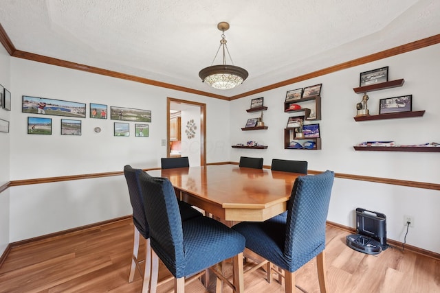 8628 N Spring Ct, Pickerington, OH 43147 - dining area featuring wood finished floors, baseboards, a textured ceiling, and crown molding