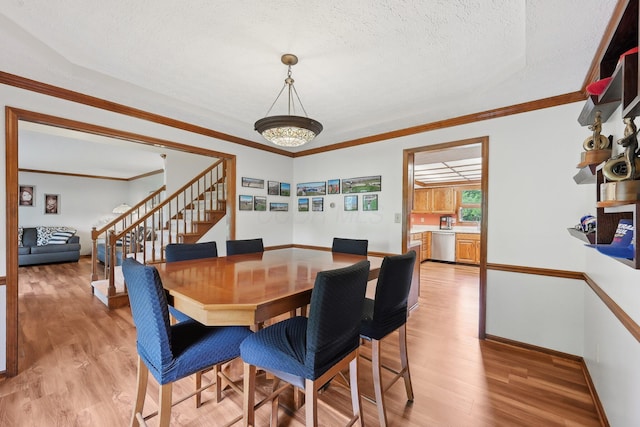 8628 N Spring Ct, Pickerington, OH 43147 - dining area featuring stairs, light wood-type flooring, a textured ceiling, baseboards, and ornamental molding