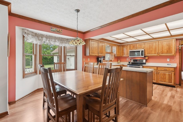 8628 N Spring Ct, Pickerington, OH 43147 - dining room featuring light wood-type flooring, baseboards, crown molding, and a textured ceiling