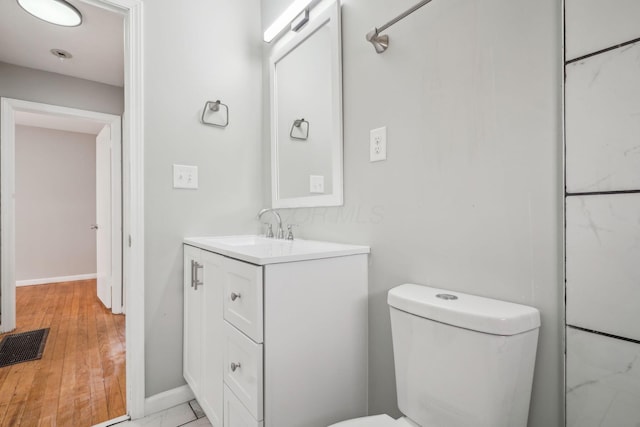 1118 E 26th Ave, Columbus, OH 43211 - bathroom with toilet, vanity, baseboards, and wood finished floors
