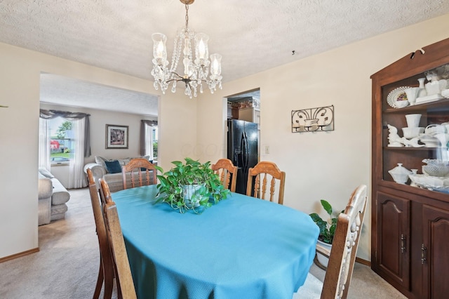 8177 Maugham Dr, Reynoldsburg, OH 43068 - dining area featuring light carpet, a chandelier, baseboards, and a textured ceiling