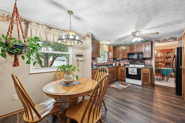 8177 Maugham Dr, Reynoldsburg, OH 43068 - dining room with dark wood finished floors, a chandelier, ceiling fan, and a textured ceiling
