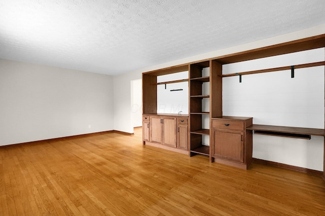 11831 Woodbridge Ln NW, Baltimore, OH 43105 - unfurnished living room featuring baseboards, light wood-type flooring, and a textured ceiling