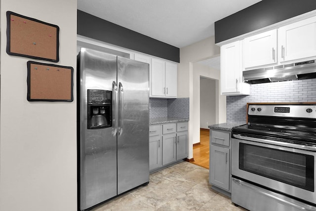 11831 Woodbridge Ln NW, Baltimore, OH 43105 - kitchen with appliances with stainless steel finishes, under cabinet range hood, backsplash, white cabinetry, and light stone countertops