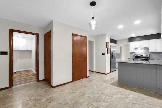 11831 Woodbridge Ln NW, Baltimore, OH 43105 - kitchen with stainless steel appliances, under cabinet range hood, baseboards, white cabinets, and dark stone counters