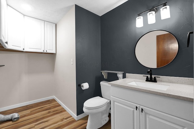 11831 Woodbridge Ln NW, Baltimore, OH 43105 - bathroom with vanity, wood finished floors, toilet, and baseboards