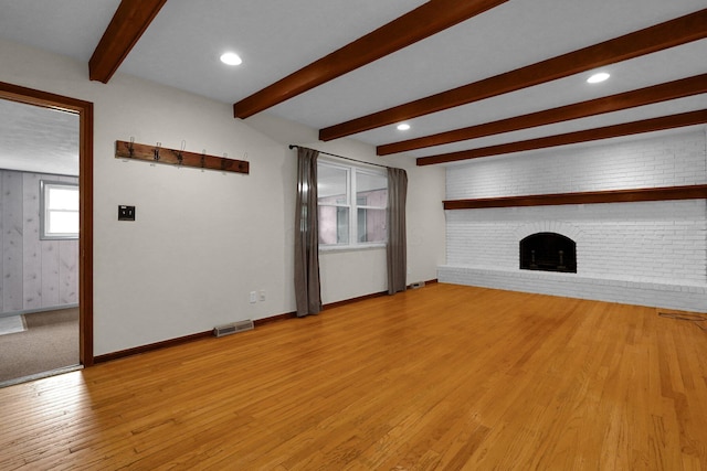 11831 Woodbridge Ln NW, Baltimore, OH 43105 - unfurnished living room with beamed ceiling, light wood-style flooring, a brick fireplace, baseboards, and recessed lighting