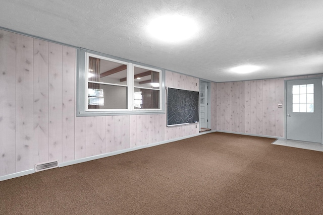 11831 Woodbridge Ln NW, Baltimore, OH 43105 - empty room featuring carpet, a textured ceiling, and wood walls