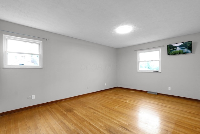 11831 Woodbridge Ln NW, Baltimore, OH 43105 - empty room featuring baseboards, light wood-style floors, and a textured ceiling