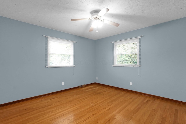 11831 Woodbridge Ln NW, Baltimore, OH 43105 - spare room featuring light wood finished floors, baseboards, a ceiling fan, and a textured ceiling