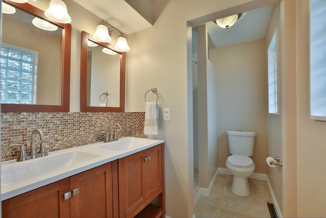 6219 Ambleside Dr, Columbus, OH 43229 - bathroom with decorative backsplash, double vanity, healthy amount of natural light, and toilet