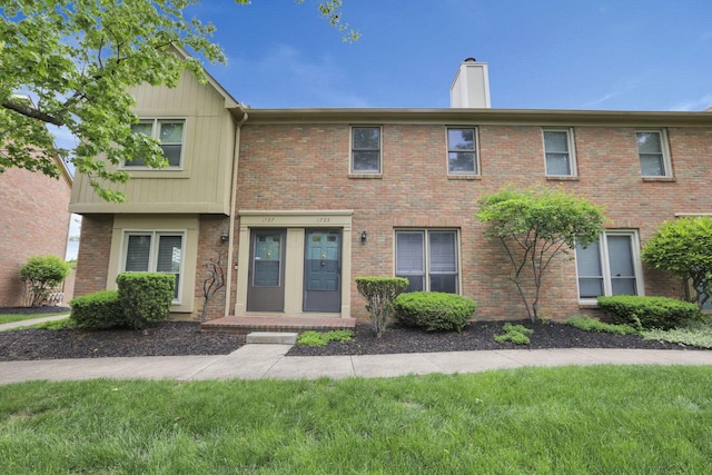 1755 Connors Point Dr, Columbus, OH 43220 - townhome / multi-family property with a chimney, brick siding, a front lawn, and board and batten siding
