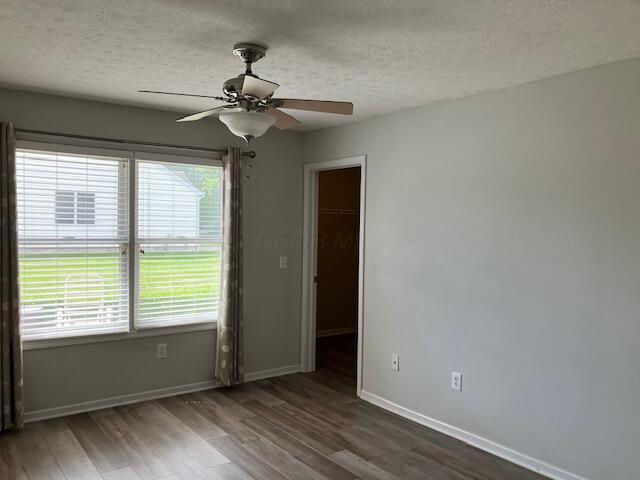 7343 Reynolds Crossing Dr, Reynoldsburg, OH 43068 - unfurnished room featuring wood finished floors, a textured ceiling, baseboards, and a ceiling fan