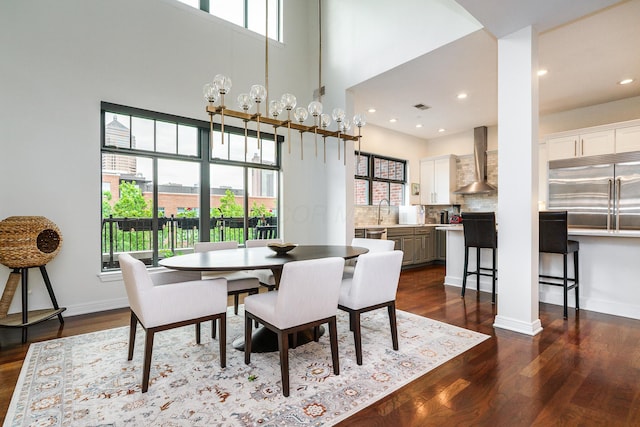 251 Daniel Burnham Sq Unit 703, Columbus, OH 43215 - dining area featuring dark wood-style floors, plenty of natural light, a towering ceiling, baseboards, and recessed lighting