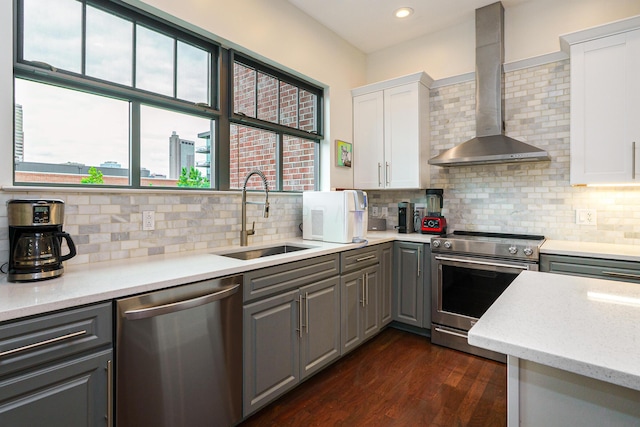 251 Daniel Burnham Sq Unit 703, Columbus, OH 43215 - kitchen featuring stainless steel appliances, wall chimney range hood, a sink, gray cabinetry, and white cabinets
