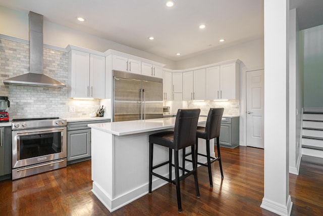 251 Daniel Burnham Sq Unit 703, Columbus, OH 43215 - kitchen with appliances with stainless steel finishes, wall chimney range hood, gray cabinetry, light countertops, and recessed lighting