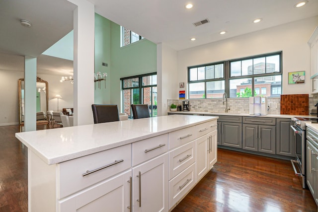 251 Daniel Burnham Sq Unit 703, Columbus, OH 43215 - kitchen with a sink, dark wood-style flooring, decorative backsplash, gray cabinets, and stainless steel range with electric stovetop