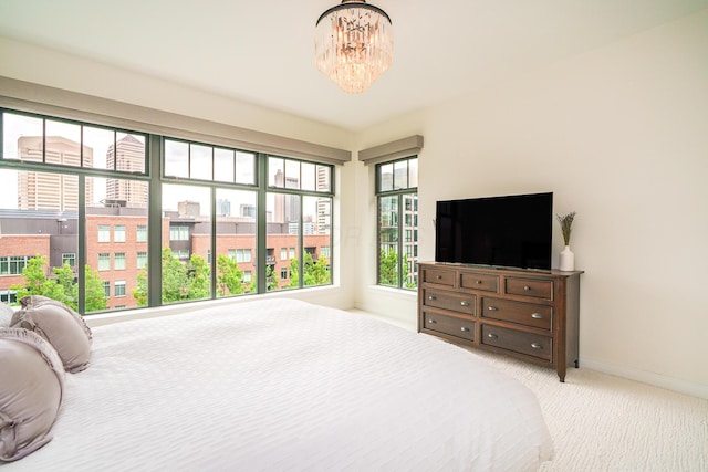 251 Daniel Burnham Sq Unit 703, Columbus, OH 43215 - bedroom with light colored carpet, a chandelier, and baseboards