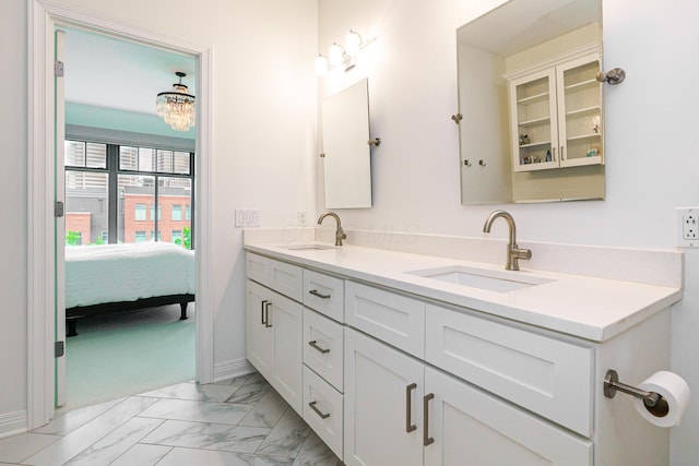 251 Daniel Burnham Sq Unit 703, Columbus, OH 43215 - ensuite bathroom with double vanity, marble finish flooring, and baseboards