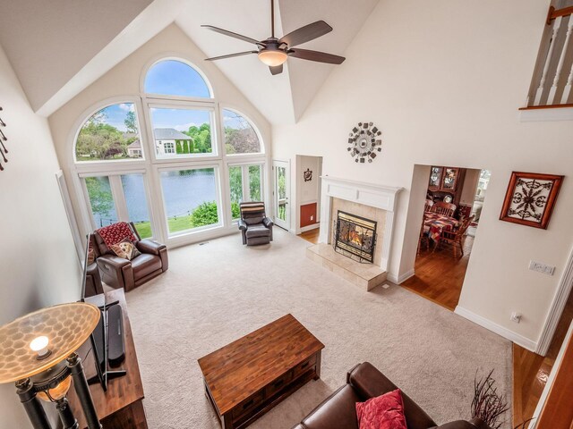 8171 Campden Lakes Blvd, Dublin, OH 43016 - living room featuring a tile fireplace, carpet flooring, ceiling fan, high vaulted ceiling, and baseboards