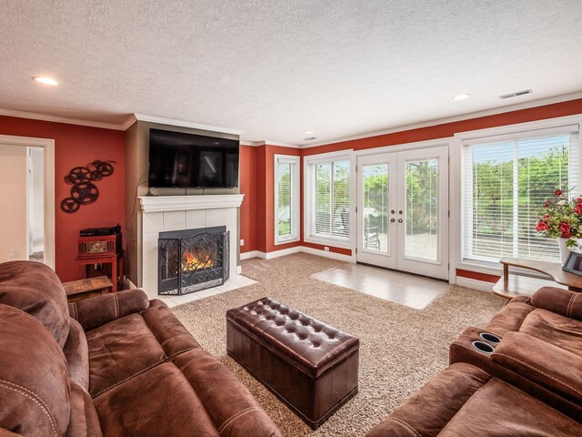 8171 Campden Lakes Blvd, Dublin, OH 43016 - living area with crown molding, a tiled fireplace, french doors, a textured ceiling, and carpet flooring