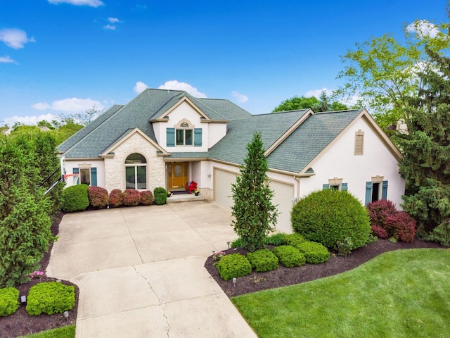 8171 Campden Lakes Blvd, Dublin, OH 43016 - view of front of house with driveway, stucco siding, a garage, a front lawn, and a shingled roof
