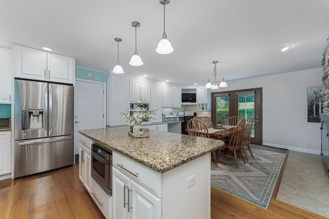 4015 Mountview Rd, Upper Arlington, OH 43220 - kitchen with stainless steel fridge with ice dispenser, light stone countertops, a center island, white cabinetry, and ornamental molding