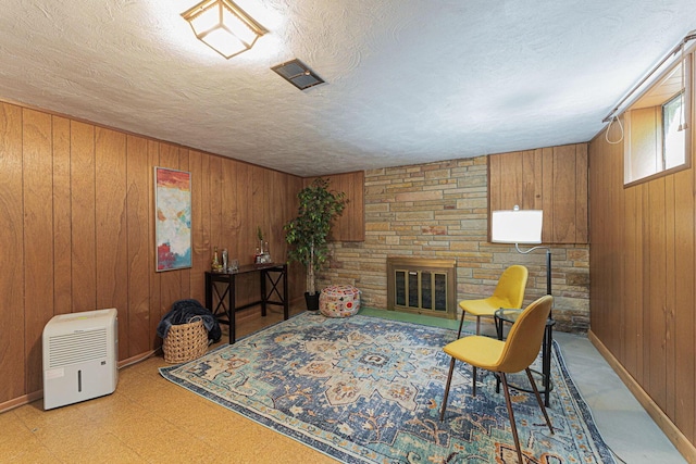 4015 Mountview Rd, Upper Arlington, OH 43220 - sitting room featuring wooden walls, light flooring, a fireplace, a textured ceiling, and baseboards