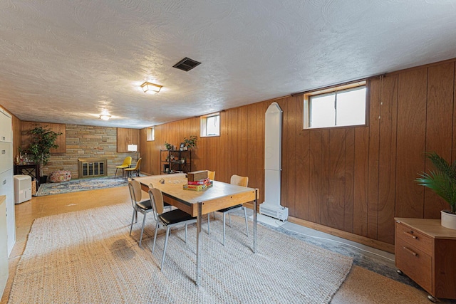 4015 Mountview Rd, Upper Arlington, OH 43220 - dining space with healthy amount of natural light, wooden walls, a stone fireplace, and a textured ceiling