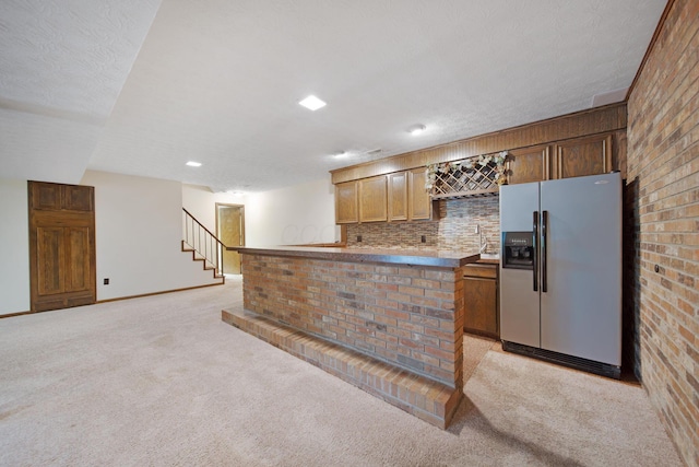 2580 Applewood Ln NE, Lancaster, OH 43130 - kitchen with stainless steel refrigerator with ice dispenser, light carpet, backsplash, baseboards, and brick wall