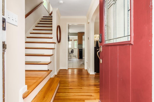 2008 N Edgemont Rd, Upper Arlington, OH 43212 - foyer with light wood-style floors, crown molding, stairs, arched walkways, and baseboards