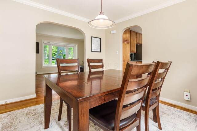 2008 N Edgemont Rd, Upper Arlington, OH 43212 - dining space with arched walkways, baseboards, light wood-style flooring, and crown molding