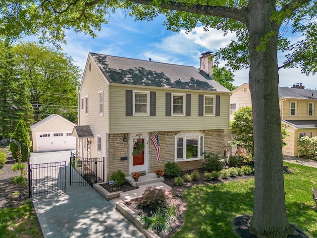 2008 N Edgemont Rd, Upper Arlington, OH 43212 - colonial house with a gate, an outdoor structure, a chimney, concrete driveway, and a detached garage