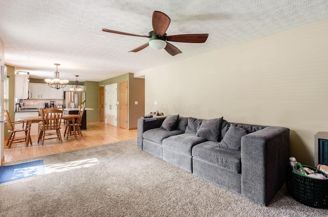 6249 Corley Dr, Dublin, OH 43016 - living room with a ceiling fan, light carpet, a chandelier, a textured ceiling, and light wood-style flooring