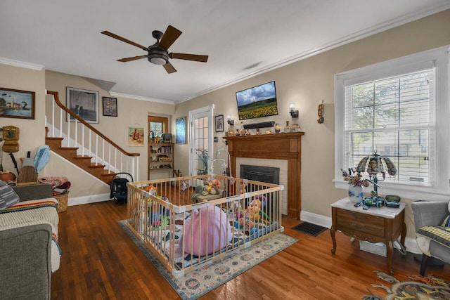 297 S James Rd, Columbus, OH 43213 - living room with ceiling fan, ornamental molding, wood finished floors, a fireplace with flush hearth, and baseboards