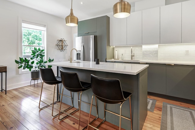 432 E Kossuth St, Columbus, OH 43206 - kitchen with stainless steel refrigerator with ice dispenser, a sink, light wood finished floors, tasteful backsplash, and recessed lighting