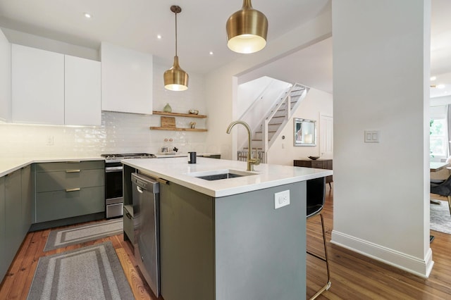 432 E Kossuth St, Columbus, OH 43206 - kitchen featuring a sink, gray cabinets, dark wood-style flooring, appliances with stainless steel finishes, and a kitchen island with sink